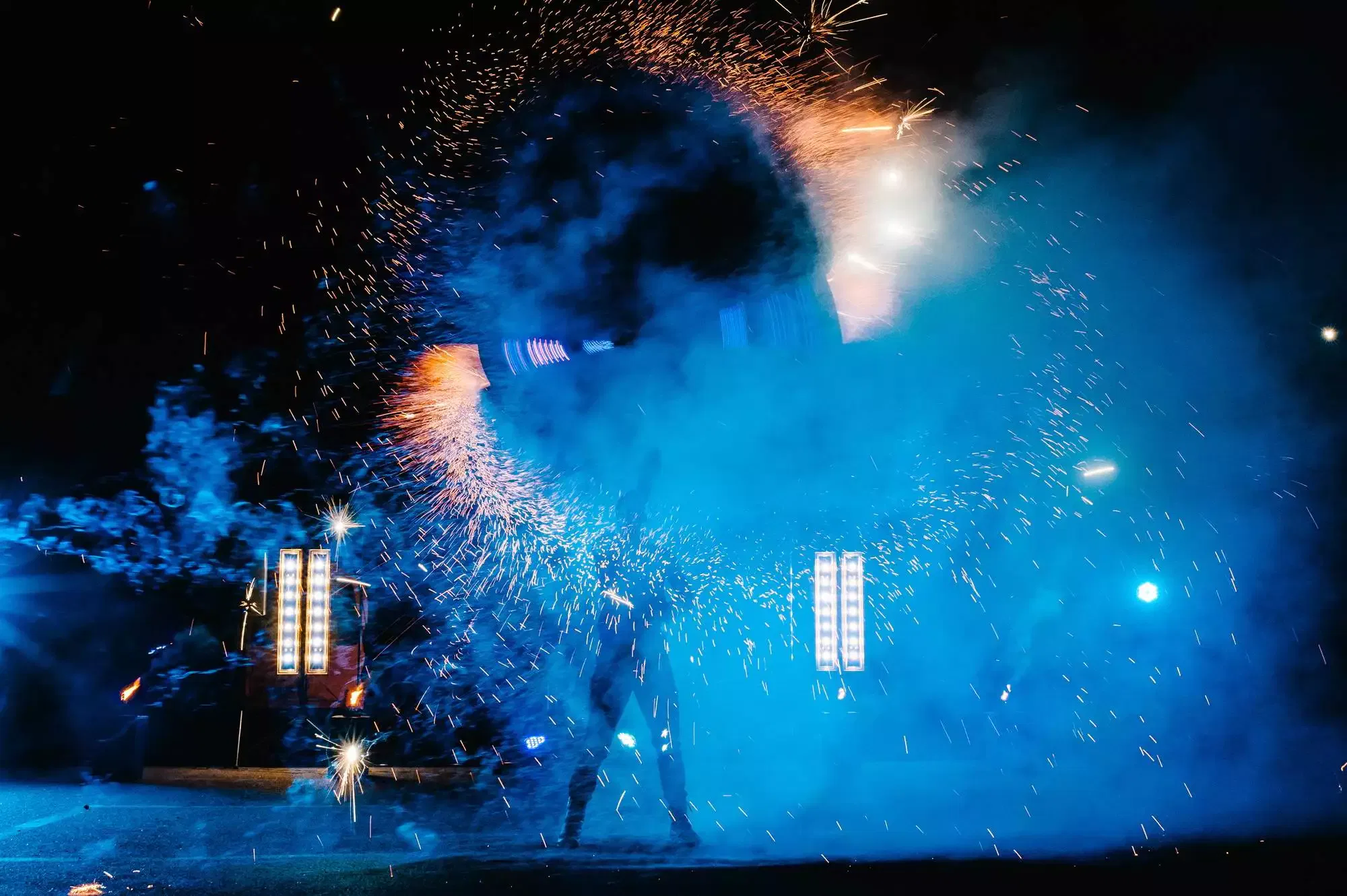 Fire show, dancing with flame, male master juggling with fireworks, performance outdoors, draws