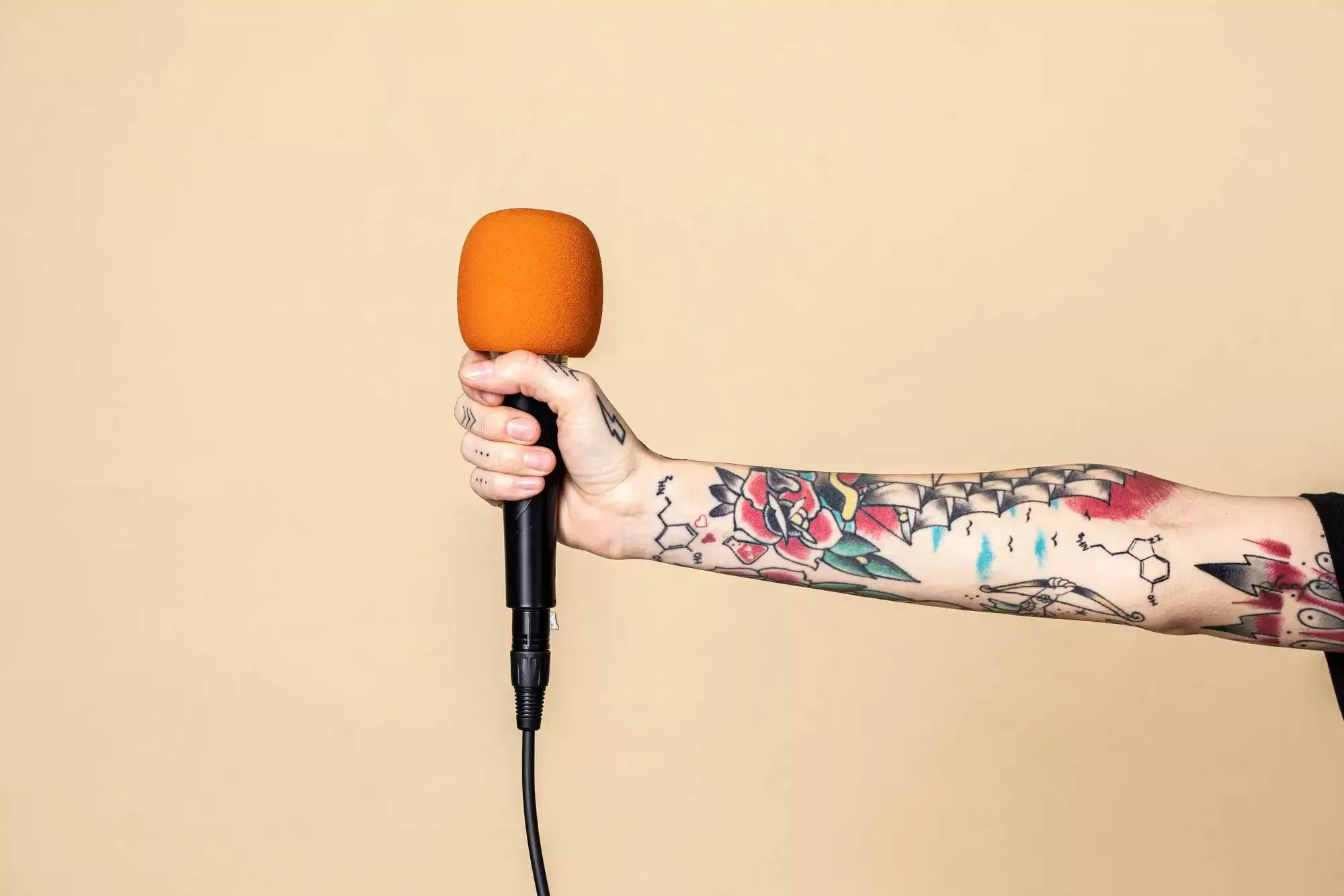 Microphone in a tattooed hand